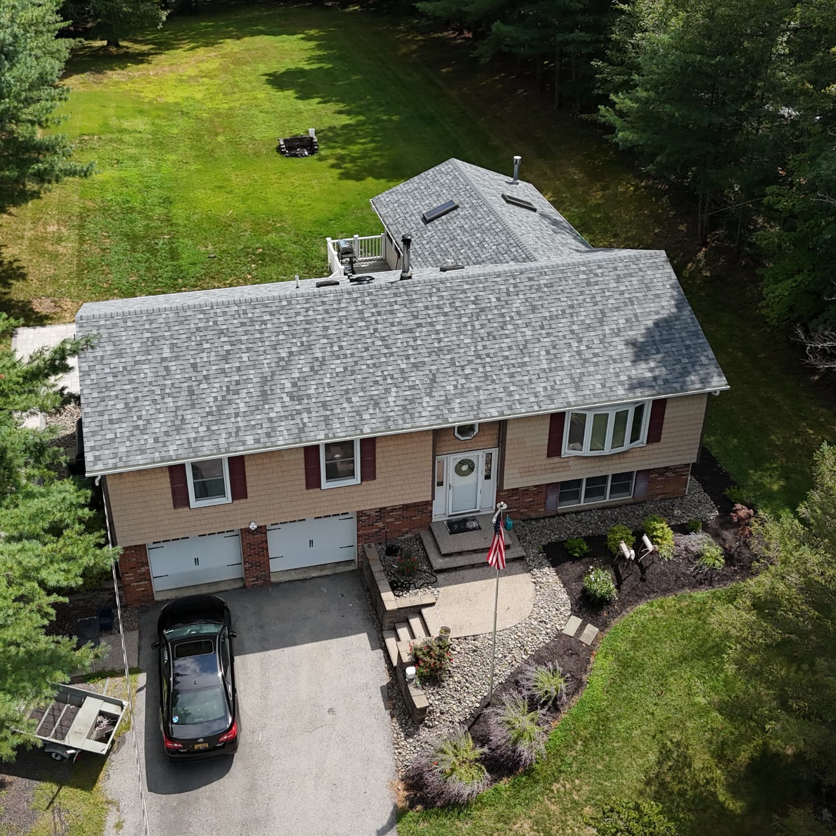 Aerial view of a new gray shingle roof on a home in Beaverdam Lake, NY